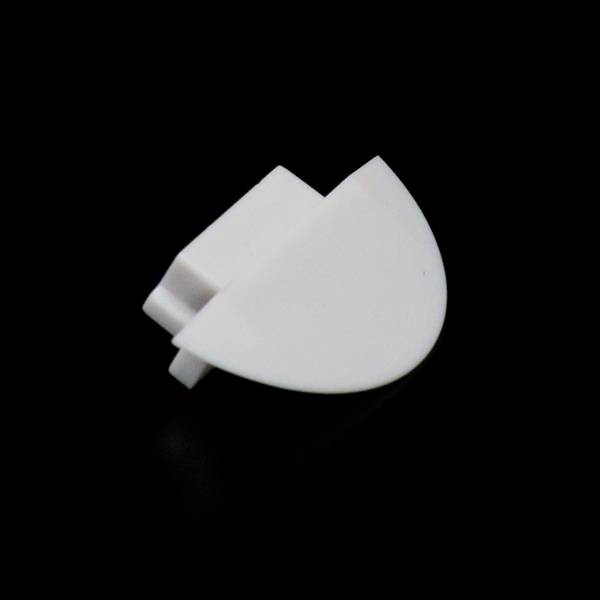Biały plastikowy klips w kształcie półkola na czarnym tle.