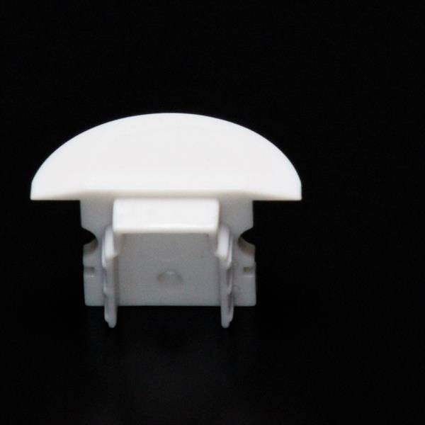 Biały, zaokrąglony klips z tworzywa sztucznego na czarnym tle, prawdopodobnie przeznaczony do mocowania kabli lub papieru.