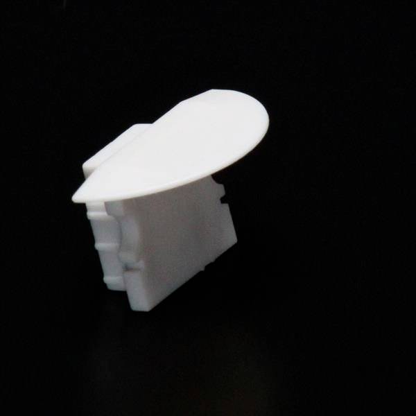 Biały, prostokątny plastikowy zamek z okrągłą rączką leży na czarnym tle.