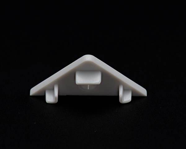 Trójkątny biały element z tworzywa sztucznego na czarnym tle, który prawdopodobnie służy jako łącznik lub uchwyt.