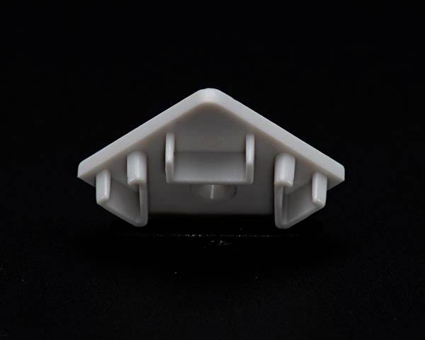 Biały, trójkątny obiekt z tworzywa sztucznego z trzema haczykami na czarnym tle.