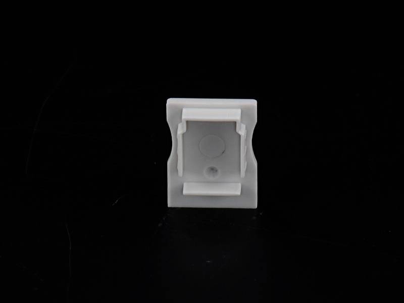 Biały kwadratowy obiekt z okrągłym środkiem jest pokazywany na czarnym tle.