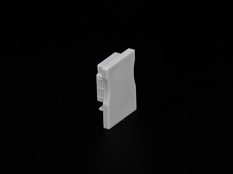 Biała, prostokątna komponenta z tworzywa sztucznego na czarnym tle.