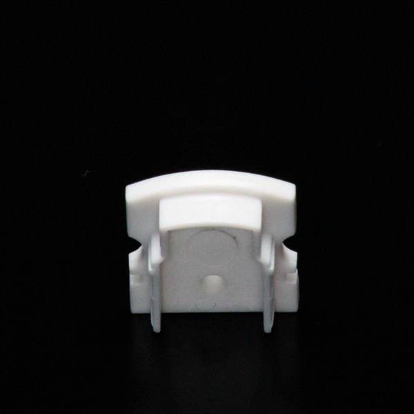 Biały, prostokątny plastikowy klips na czarnym tle. Odpowiedni do mocowania przewodów lub cienkich obiektów.