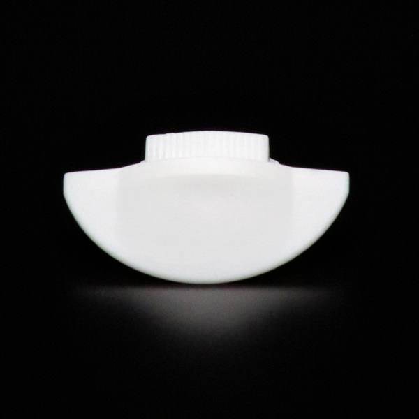 Biały obiekt plastikowy o okrągłym kształcie z żeberkowaną krawędzią, na czarnym tle.