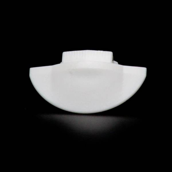 Biały, półokrągły przedmiot na czarnym tle przypomina część zamknięcia lub nakładki.