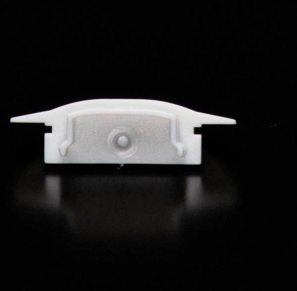 Biały, prostokątny obiekt z tworzywa sztucznego o płaskiej konstrukcji na czarnym tle, prawdopodobnie element techniczny lub mechaniczny.