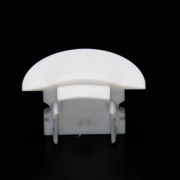 Biała część z tworzywa sztucznego na czarnym tle. Posiada wypukłą górną powierzchnię i dwa boczne uchwyty.