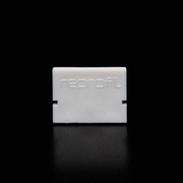 Biały, prostokątny przedmiot na czarnym tle z napisem 'reprofit'.