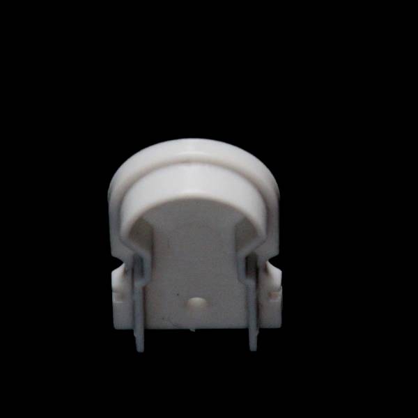 Biały, wtykowy element z tworzywa sztucznego z dwoma metalowymi stykami na czarnym tle, prawdopodobnie elektryczny adapter.