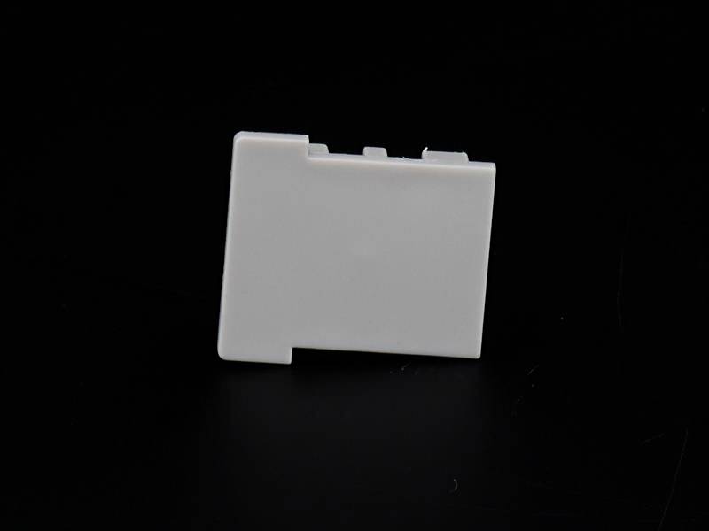 Biała, prostokątna osłona z tworzywa sztucznego na czarnym tle, prawdopodobnie będąca częścią urządzenia elektronicznego.