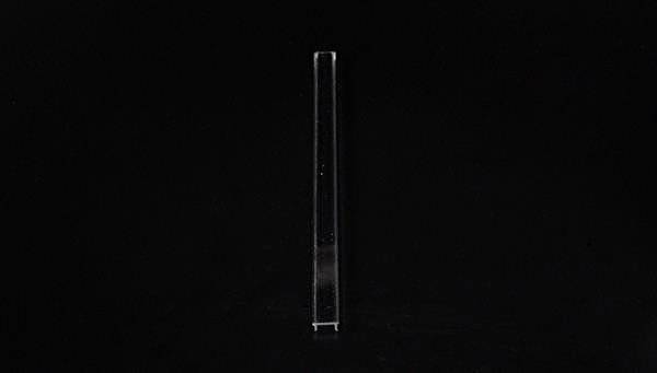 Pojedyncza przezroczysta probówka na czarnym tle.