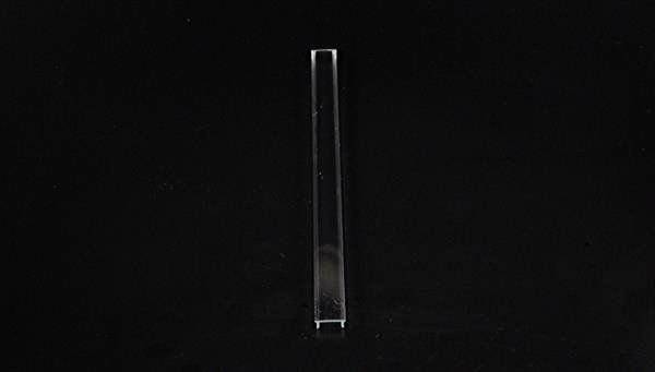 Przezroczysty, pionowo ustawiony obiekt na czarnym tle.