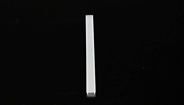 Biały, wąski słupek stoi pionowo na czarnym tle.