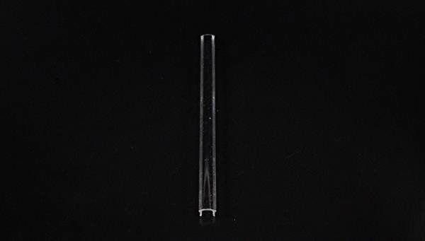Przezroczysta szklana rurka na czarnym tle.