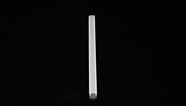 Prosty, biały obiekt stoi pionowo pośrodku czarnego tła.