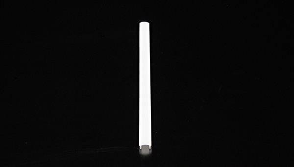 Pojedyncza biała świeca na czarnym tle.