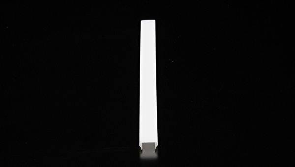 Biały, prostokątny pasek plastikowy stoi pionowo na czarnym tle.