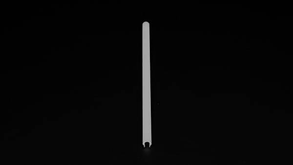 Pojedynczy biały słomka stoi pionowo na czarnym tle.