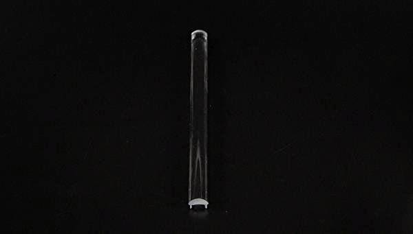 Pojedyncza, przezroczysta probówka na czarnym tle.