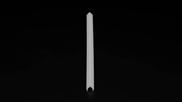 Pojedynczy, biały, podłużny plastikowy korek stoi pionowo na czarnej powierzchni.