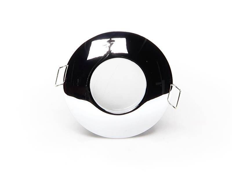 Błyszczący, okrągły lustro z dwoma kwadratowymi uchwytami po bokach. Lustro odbija światło padające z góry.