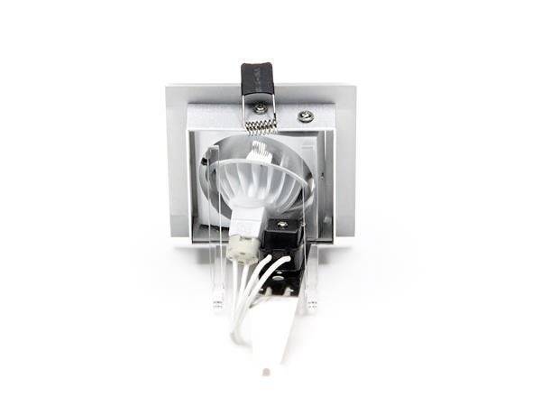 Kwadratowy spot podtynkowy z srebrną ramką, prezentujący widoczne źródło światła i podłączone przewody. Nadaje się do montażu sufitowego.