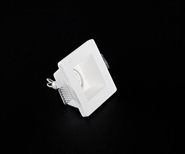 Kwadratowa, biała oprawa wpuszczana z czarnym tłem; odpowiednia do nowoczesnych wnętrz.