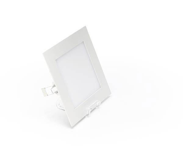 Kwadratowa biała lampa sufitowa LED na białym tle. Jest lekko pochylona, z widocznym klipsem mocującym na tylnej stronie.