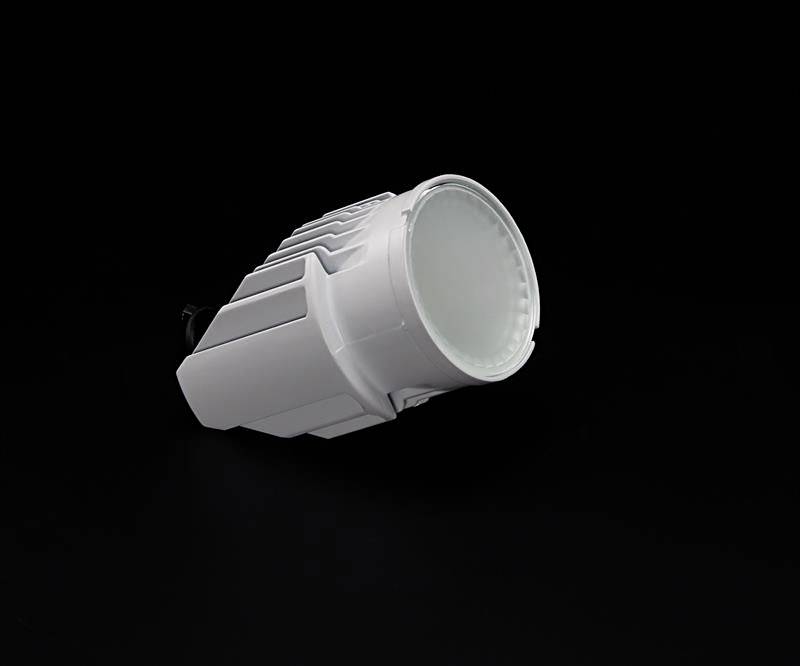 Biała lampa LED na czarnym tle. Projekt jest nowoczesny, z żebrowaną obudową służącą do odprowadzania ciepła.