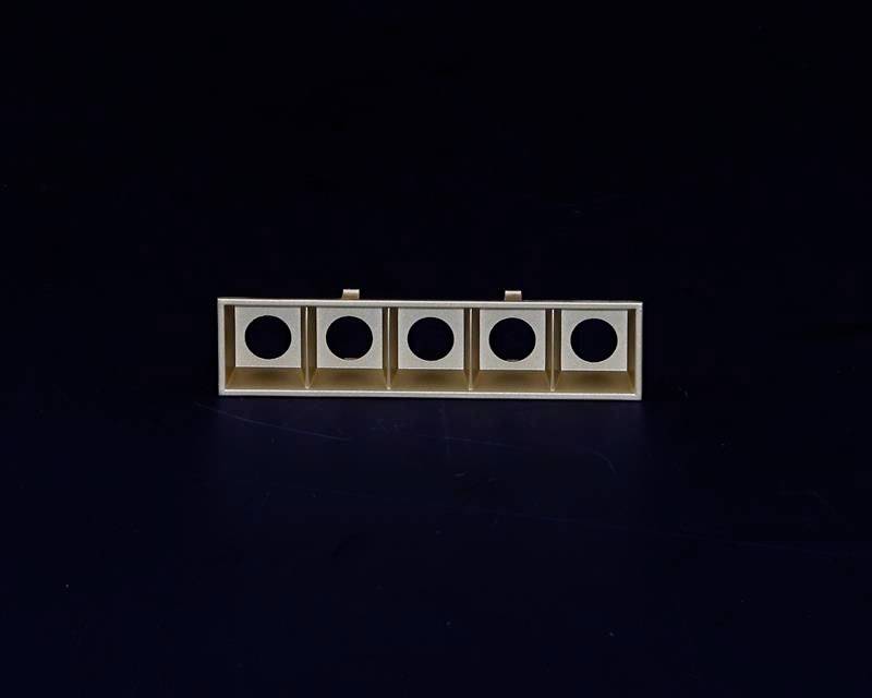 Prostokątny element konstrukcyjny z pięcioma otworami kołowymi, równomiernie rozmieszczonymi wzdłuż krawędzi, na ciemnym tle.