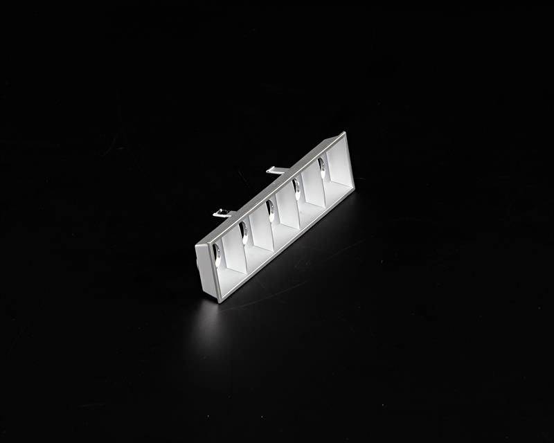 Prostokątna, biała lampa sufitowa z pięcioma kwadratowymi zagłębieniami na czarnym tle. Idealna do nowoczesnego oświetlenia wnętrz.