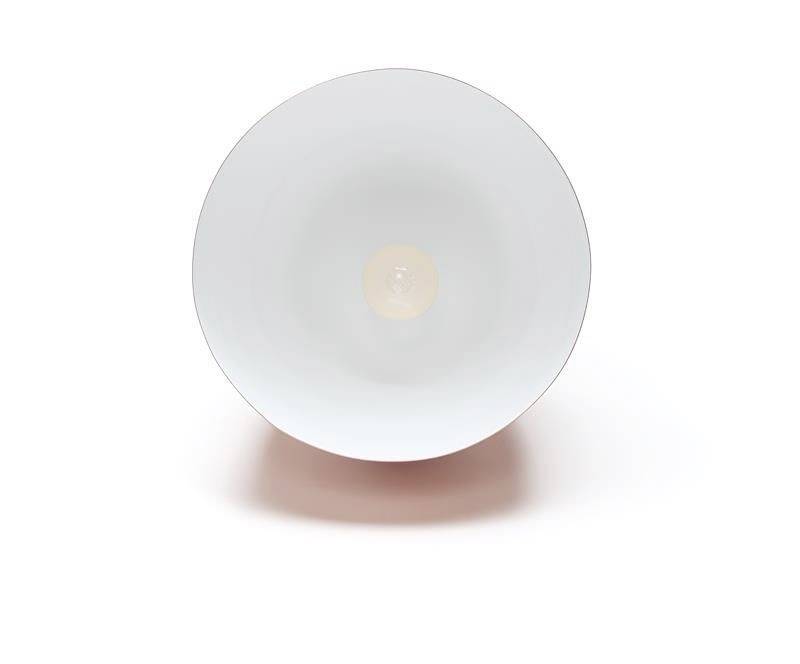 Minimalistyczna, okrągła, biała miska sfotografowana z góry, z małym, centralnym punktem pośrodku.