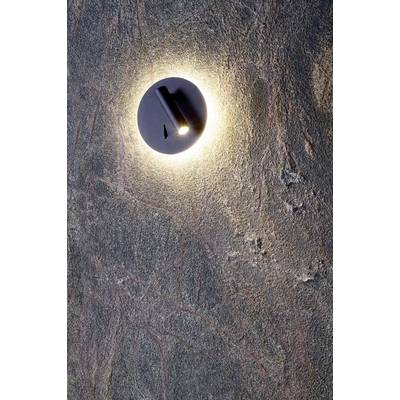 Lampa w kształcie koła, rzucająca ciepłe światło na strukturalną kamienną ścianę.