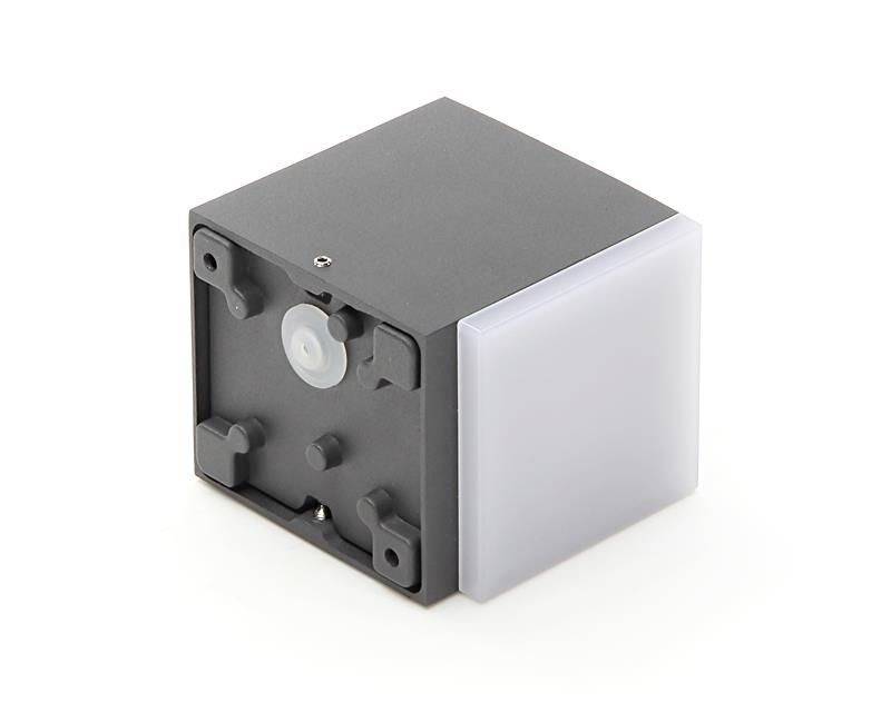 Czarny sześcian z białą, gładką stroną oraz technicznym tyłem wyposażonym w przyciski i czujniki, umieszczony na białym tle.