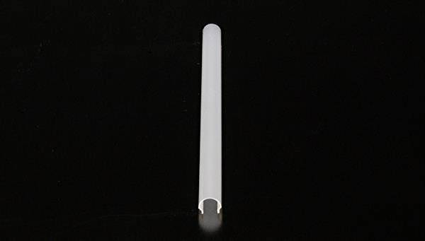 Pojedynczy, wydłużony, biały obiekt leży na ciemnej powierzchni. Wygląda jak mała rurka lub przewód.