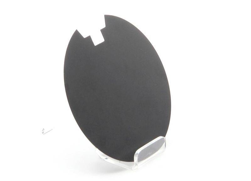 Okrągła, czarna płytka krzemowa z prostokątnym nacięciem na krawędzi, prezentowana na przezroczystym stojaku.