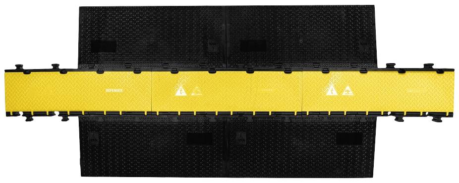 Żółto-czarna kładka kablowa z wieloma kanałami, zapewniająca bezpieczne prowadzenie przewodów i zabezpieczenie przed ryzykiem potknięcia w środowiskach pracy.