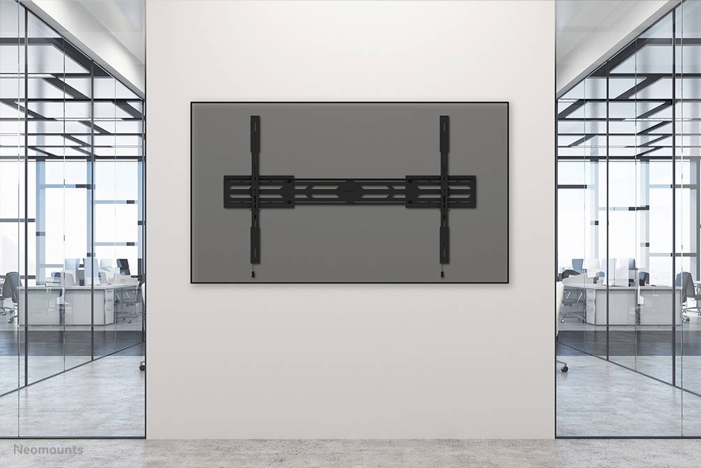 Biuro z nowoczesnymi przegrodami szklanymi i schludnymi stanowiskami pracy. Na ścianie wisi duży czarny ekran.