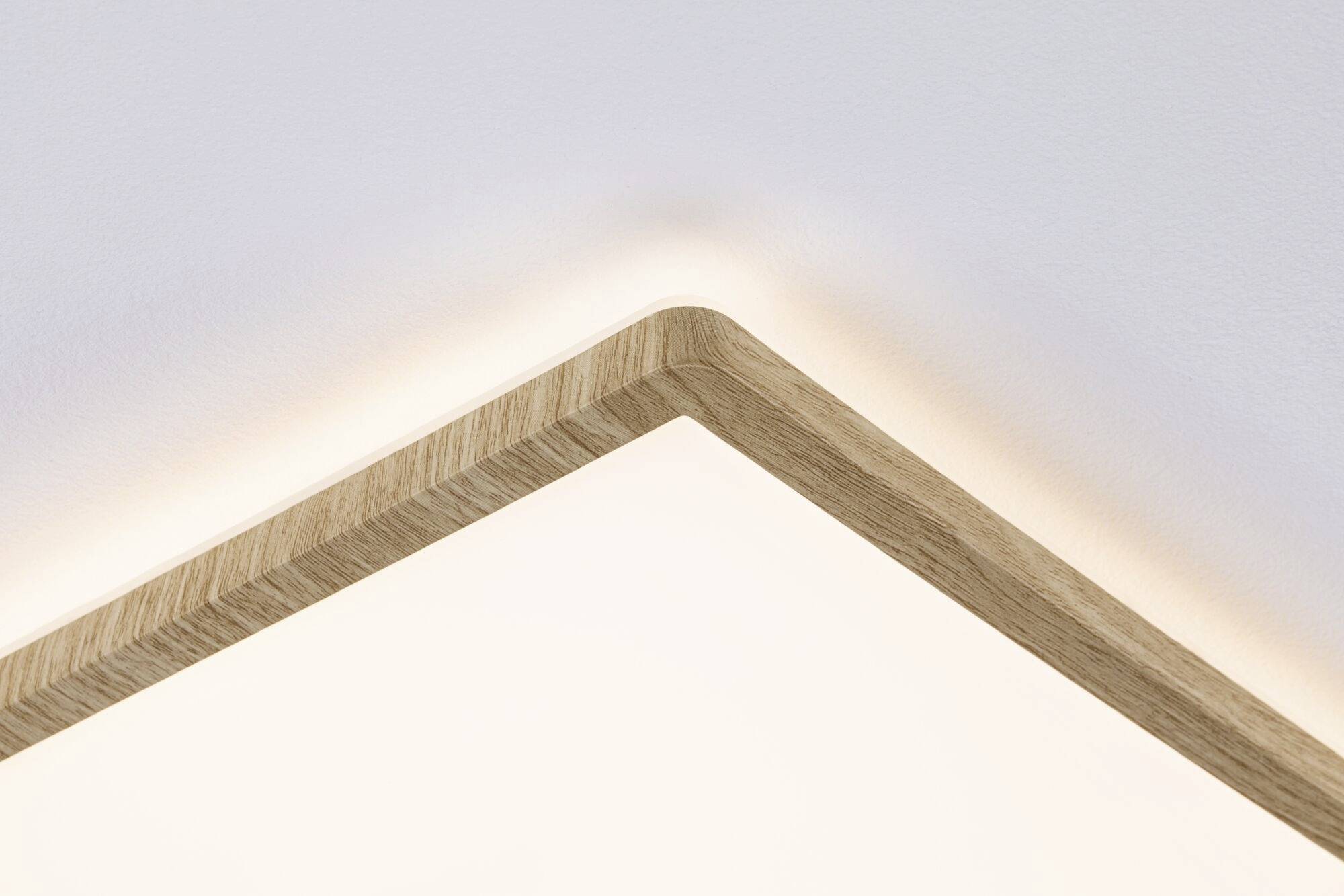 Kwadratowa lampa sufitowa LED z drewna z delikatnym rozproszeniem światła na suficie, o nowoczesnym i minimalistycznym designie.