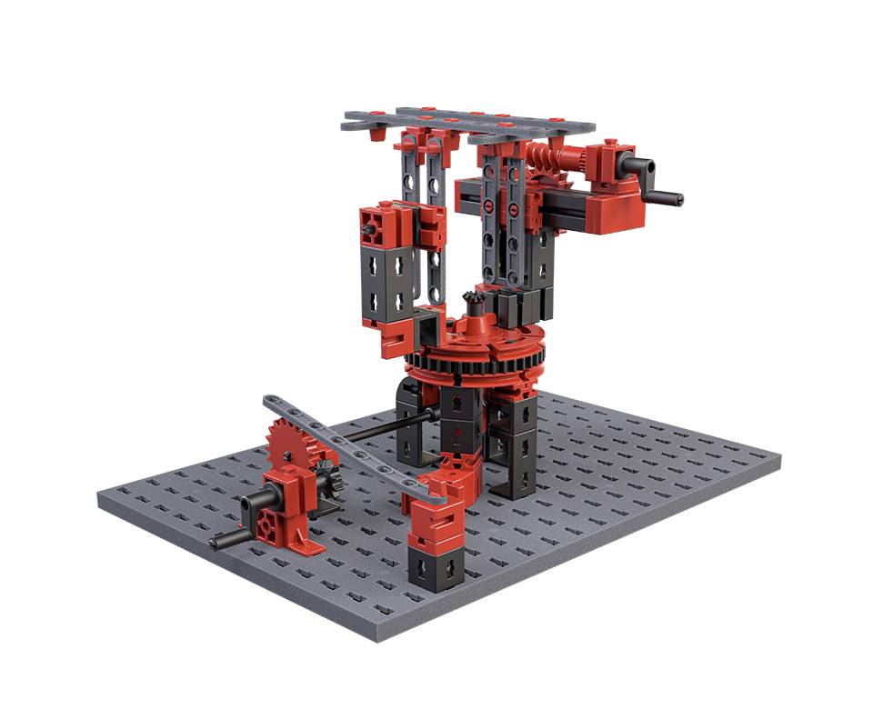 Zestaw konstrukcyjny ramienia robota na szarej podstawie, składający się z czerwonych i czarnych elementów z kołami zębatymi i dźwigniami.