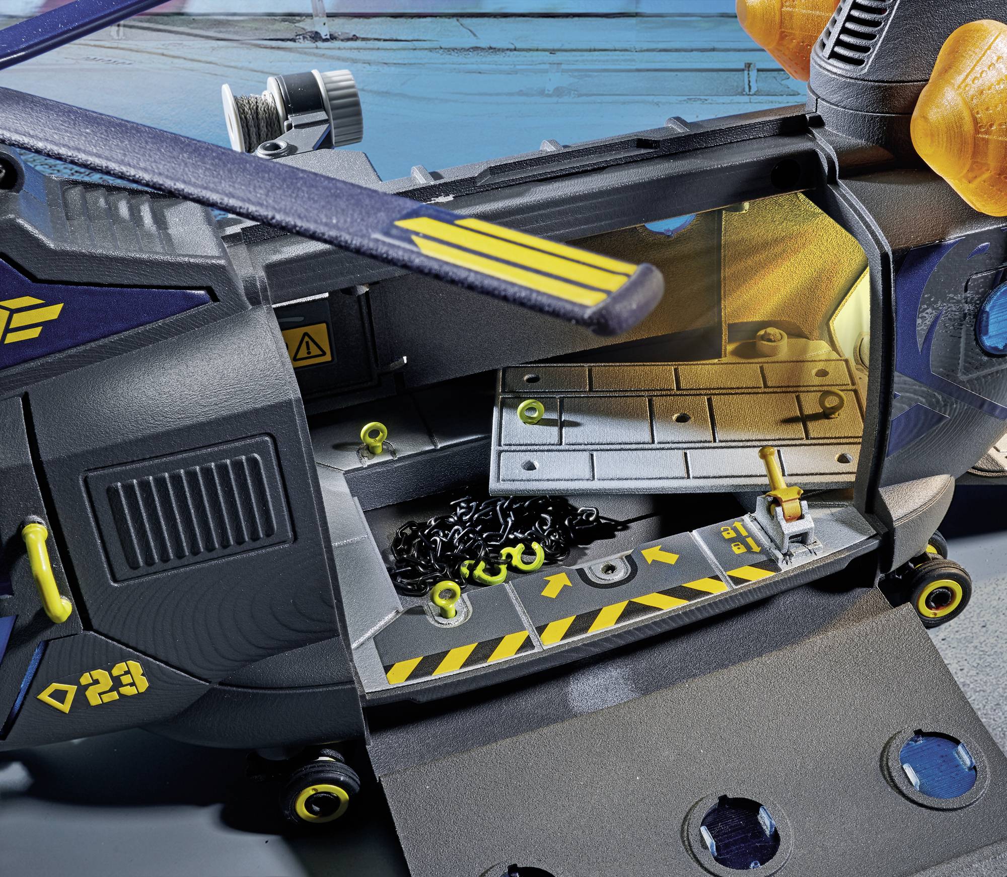 Model helikoptera z otwartą przestrzenią ładunkową, wewnątrz łańcuchy i zamki. Na zewnątrz żółte oznaczenia i numery.