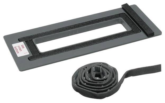 Szary prostokątny element plastikowy z prostokątnym otworem, obok niego zwinięta uszczelka piankowa.