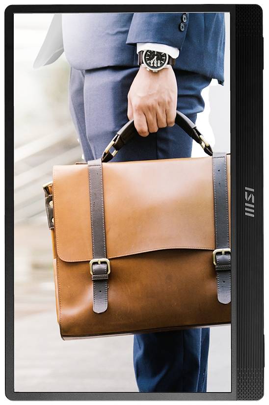 Mężczyzna w niebieskim garniturze niesie w ręku brązową skórzaną torbę. Na nadgarstku widać zegarek na pasku.