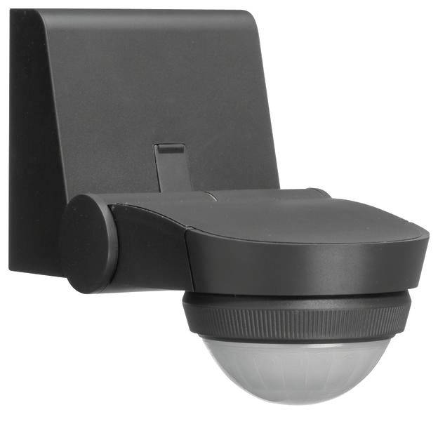 Czujnik ruchu na zewnątrz zamontowany w czarnej obudowie na ścianie. Służy do wykrywania ruchu w przestrzeni zewnętrznej.