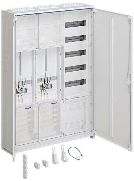 Otwarty rozdzielnik elektryczny z wieloma przegrodami, przewodami i elementami elektronicznymi. Przed nim leżą akcesoria, takie jak pokrywy i przewody.