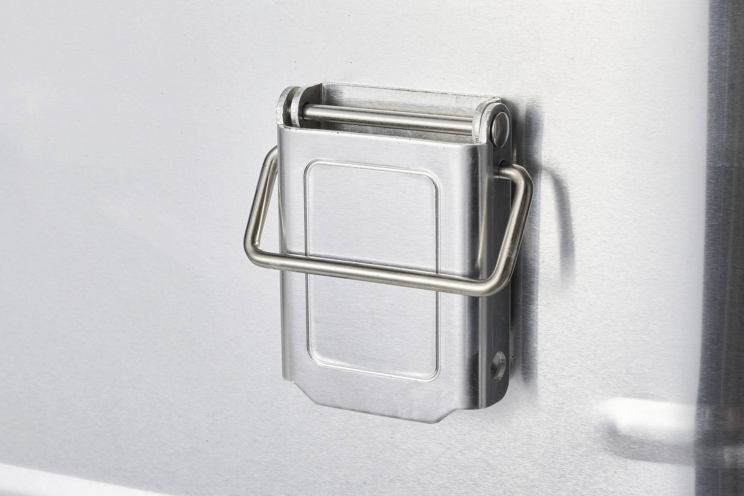 Metalowy zamek z składanym uchwytem na srebrnych drzwiach.