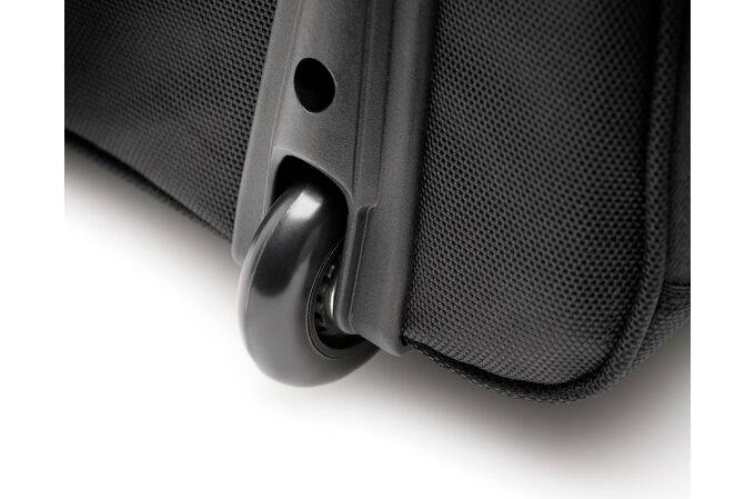 Zbliżenie czarnego kółka bagażowego na walizce, ukazujące szczegóły i jakość materiału walizki.