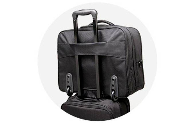 Czarna torba na laptopa z teleskopową rączką bezpiecznie spoczywa na walizce na kółkach, co pozwala zmniejszyć obciążenie podczas noszenia.