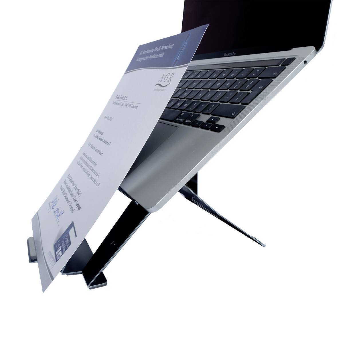 Laptop na czarnym stojaku z uchwytem na papier. Dokument na papierze zawiera informacje certyfikacyjne.